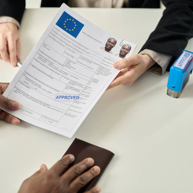 Top view closeup of black man holding approved visa application form in immigration office