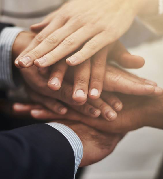 Cropped shot of a group of businesspeople putting their hands together in unity.